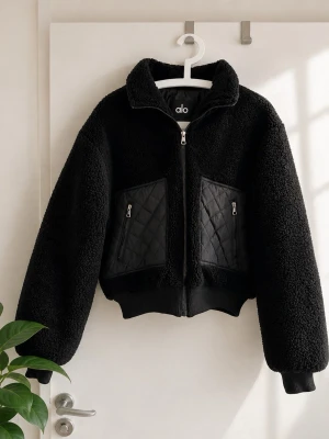 Svart teddyjacka från Alo - Alo Teddy Fleece Jacka – Svart – Stl S  Säljer en snygg teddyjacka från Alo i storlek S. Jackan är sparsamt använd och i mycket fint skick.  Detaljer: 	•	Märke: Alo 	•	Storlek: S 	•	Färg: Svart 	•	Mjuk teddyfleece med quiltade detaljer 	•	Dragkedja framtill 	•	Två fickor med dragkedja 	•	Croppad modell med ribbade muddar  Perfekt som övergångsjacka eller för svala dagar. Enkel att matcha med både vardags- och träningskläder.  Skick: Mycket fint skick utan hål eller fläckar.  