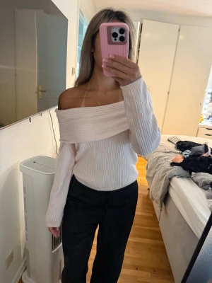 Off shoulder ljusrosa stickad tröja - Säljer en snygg off shoulder stickad tröja i ljusrosa. Tröjan har bred krage som vilar över axlarna och är ribbstickad för en trendig look. Långa ärmar och mjukt material som känns skönt mot huden. Perfekt för dig som vill ha en stilren och modern outfit.