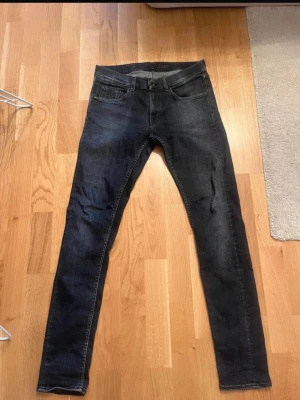 Mörkblå slim fit jeans - Säljer ett par mörkblå slim fit jeans med klassisk femficksdesign och smal passform. Jeansen har diskreta slitningar och är tillverkade i ett stretchigt denimtyg för extra komfort. Perfekta för dig som gillar en modern och stilren look.