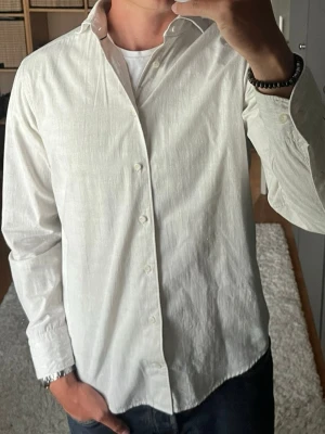 Eton skjorta i beige - stl 39 (M) - 100% bomull i ett tunt tyg med lite ojämn yta, påminner om linne. Slim fit och bred krage, skön nu på sommaren och funkar både öppen och knäppt. Personen på bilden är 189cm, väger 78kg.  Använd men i mycket fint skick, inga hål eller fläckar.  Rök- och djurfritt hem. Skriv gärna om du vill ha fler bilder eller undrar något!