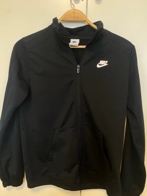 Svart helzip från Nike - Storleken är 150-170 barnstorlek, passar dock även om man är xs eller s men inte så lång eller bred.
