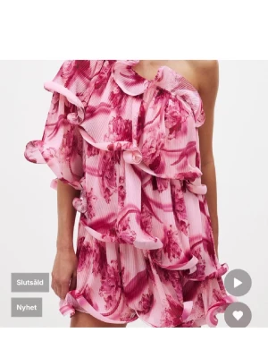 Lojsan x nakd klänning  - Säljer denna otroligt fina klänning från lojsans kollektion med nakd som ej finns att köpa längre! Superfin kort klänning i rosa och rött med blommigt mönster och volangdetaljer. Klänningen har oneshoulder-design och är tillverkad i ett lätt, plisserat material som ger en luftig känsla. Perfekt för sommarens alla tillfällen.