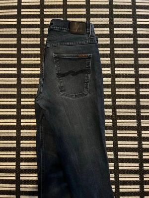 Navy blue  jeans från Nudie Jeans - Navy blue jeans från Nudie Jeans med klassisk vågsöm på bakfickan. Jeansen är i denim och har en rak passform. De är rätt så vintage men trots inget håll eller skada pågrund av bra kvalitet och en perfekt mängd washed.