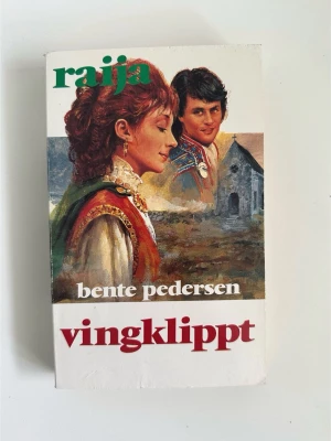 ”Vingklippt” av Bente Pedersen - Raija 17 - Boken ”Vingklippt” av Bente Pedersen. Fristående del i den storslagna Raija - serien, en släkt- och kärlekssaga fylld av mystik och trolldom, där livet vid nordkalotten prövas av öde, passion och kamp för frihet. En episk berättelse om kärlek, hämnd och övernaturliga krafter.  ISBN: 91-7710-459-5.