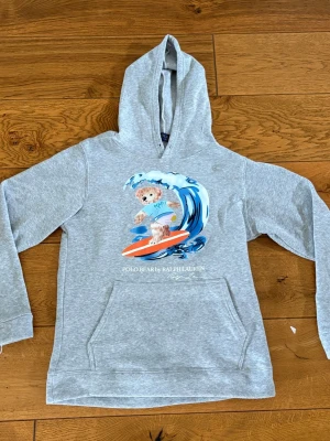 Ralph lauren hoodie - Säljer en grå hoodie från Ralph Lauren. Är i storlek M men passar mer som S. Tröjan har även avklippta snören vid luvan. Obs: Vet ej om tröjan är äkta därför lägre pris.