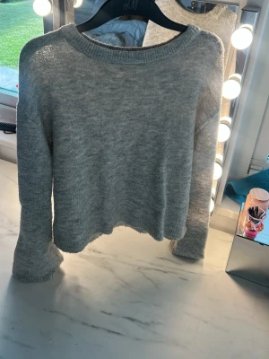 Ljusgrå stickad tröja från H&M - Mysig ljusgrå stickad tröja från H&M med rund halsringning och långa ärmar. 