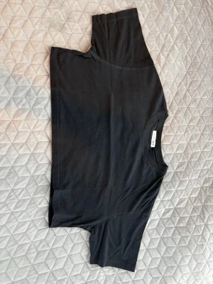 Svart croppad t-shirt Terranova - En svart croppad t-shirt från Terranova i mjuk bomull. Klassisk rund halsringning och korta ärmar. Perfekt till jeans eller kjol för en enkel och clean look.