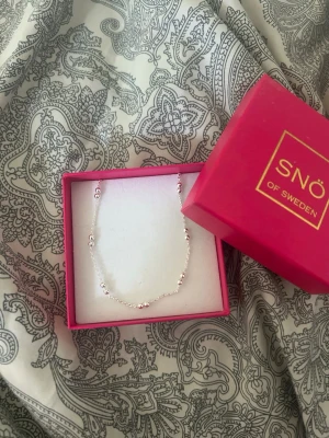 Silverhalsband med pärldetaljer SNÖ - Stilrent silverfärgat halsband från SNÖ of Sweden. Kedjan är 47cm lång. 