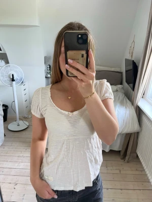 Odd Molly blus - Ljus rosa blus från Odd Molly med korta puffärmar och liten rosettdetalj vid urringningen. Använd fåtal gånger. Storlek 0 vilket brukar motsvara XS 