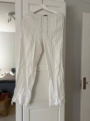 Vita linnebyxor från BikBok XS - Säljer ett par vita linnebyxor från BikBok i storlek XS. Byxorna har resår i midjan och raka ben med avslappnad passform. Perfekta för sommaren och lätta att matcha med olika toppar. Materialet är tunt och luftigt linne.