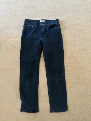Mörkblå raka jeans Acne Studios - Snygga mörkblå jeans från Acne Studios med rak passform och klassisk femficksdesign. Jeansen har normal midja, silverfärgade nitar och knapp samt diskreta sömmar. Tillverkade i denim med en stilren look.