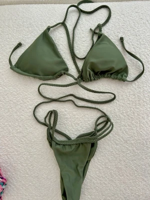 Grön bikini med flätade band - ✨Olivgrön bikini med flätade band och justerbar passform. Stilren modell som passar perfekt till sommaren. Mycket fint skick.