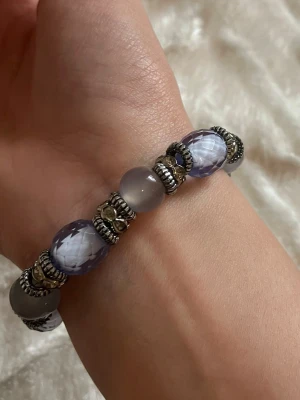 Armband med blå pärlor - Handgjort armband med facettslipade blå och grå pärlor, dekorerat med silvriga detaljer och små glittrande stenar. Armbandet är elastiskt och passar de flesta handleder 😊