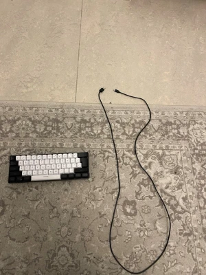 Kompakt svartvit tangentbord - Säljer ett kompakt mekaniskt tangentbord i svart och vitt med nordisk layout. Tangentbordet har en minimalistisk design och levereras med en löstagbar svart USB-kabel. Perfekt för dig som vill ha ett smidigt och portabelt tangentbord till datorn.den har rgb och har alla färger rgb