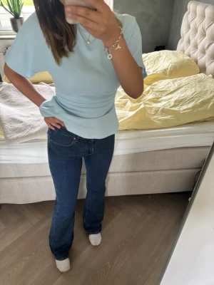 Mörkblå bootcut jeans - Snygga mörkblå bootcut jeans med klassisk femficksdesign och normal midja. Jeansen har en tidlös passform som sitter skönt över höfterna och släpper ut lite vid bensluten. Perfekta till en avslappnad och trendig look.