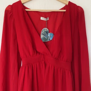 Jätte fin röd klänning - Den är i perfekt skick och aldrig använd. Kvittot finns tillåmed kvar(silvriga hjärtat)❤️ den är jätte fin och har ett rep som man kan knyta om midjan