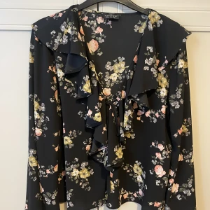 Blommig blus från Topshop - Fantastiskt fin blus från topshop Knytning framtill (se bild 2) men syns ej när den är stängd Fint skick, sparsamt använd