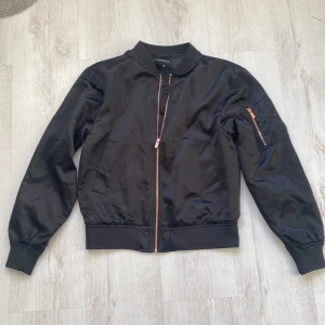 Årets bomberjacka som är SLUTSÅLD, HELT NY! - Sommarens snyggaste bomberjacka i svart med rosé dragkedja, helt ny och oanvänd.  Stl XS