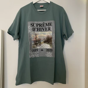 Supreme D'Hiver FW19  T-shirt  - Supreme D'Hiver FW19  T-shirt   Dusty Teal  Storlek herr L  Ny aldrig använd 