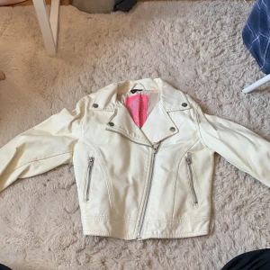 Skinnjacka barn - En creme-vit skinnjacka för barn. Fina detaljer sömmar. 