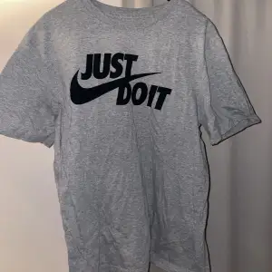 Grå T-shirt med Nike tryck framtill