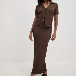 brunt set med kjol och topp🤎 - Helt oanvänt brunt set från NA-KD (prislappar kvar)🤎 nypris 650kr men säljer för 350kr för båd delar!! Stretchigt material så formar kroppen fint. Storlek xs men passar även mig som har S💞