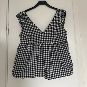 Rutig Festtopp - Säljer denna otroligt snygga rutiga topp med ett knyte bak i ryggen. Toppen är använd 1 gång och  Storleken är M men passar även S. Säljer för 150kr💓