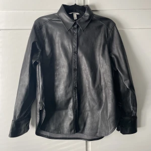 Skjorta i fusk skinn - Skjorta från H&M i storlek S. Jättesnygg men kommer inte till användning längre, därav säljer jag den. FRAKT tillkommer på priset 💞