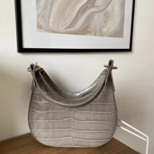 & other stories handväska - & Other Stories -  Croc embossed leather shoulder bag i grå. Använd en gång och har inget att anmärka på! Hämtas i Sundbyberg eller postas mot fraktkostnad.