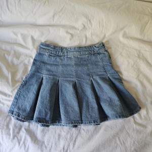 Plisserad minikjol i jeans material från Pull&Bear.  Lite liten i stroleken men knappt använd och i bra skick! Jättefin kjol men används inte.. Är fin nu till hösten med ett par strumpbyxor under💕