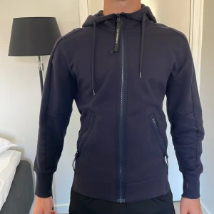 Cp Company kofta  - Cp Company kofta marin blå, modellen är 175 cm och väger 68 kg, väldigt bra skick, knappt använd, köpt för 3199kr säljer för 2599kr, passform perfekt