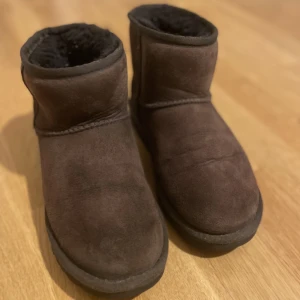 Uggs mini stl 37 - Säljer mina fina Uggs i färgen chocolate. Fint skick. Använda ett par ggr ca en säsong, så inte slitna och har mkt kvar att ge. Nypris 2200 kr. Se bilder för skick  Använd gärna köp nu :)  priset ej prutbart tyvärr då skicket är så gott
