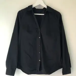 En mycket fin svart skjorta, lite mer åt det figursydda hållet. Endast använd en gång. Är som ny! 