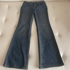 Lågmidjade utsvängda jeans från comycom. Storlek w30l34. Yttre mått 112 cm, innerbensmått 90 cm, midjemått rakt över 38 cm. Mycket fint skick, lite slitna längst ner. 