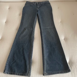 Utsvängda jeans - Lågmidjade utsvängda jeans från comycom. Storlek w30l34. Yttre mått 112 cm, innerbensmått 90 cm, midjemått rakt över 38 cm. Mycket fint skick, lite slitna längst ner. 