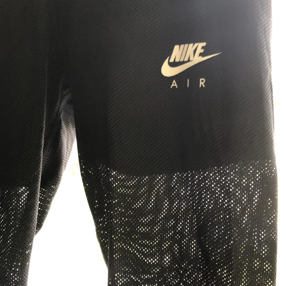 Svarta Nike air träningstights med shorts under och ett tunt luftigt tyg över  Stretchiga i midjan och går även att knyta i midjan Ficka med dragkeja på midjeresåren på baksidan. Jeans & Byxor.