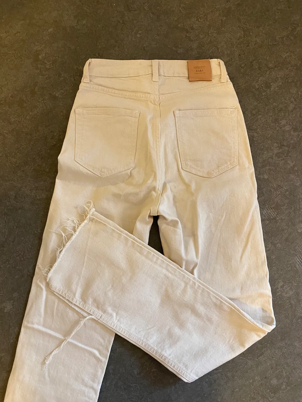 Skitsnygga jeans från Zara i beige/krämvit med slit och hög midja⚡️ett litet märke på fickan där bak, se sista bild. Jeans & Byxor.