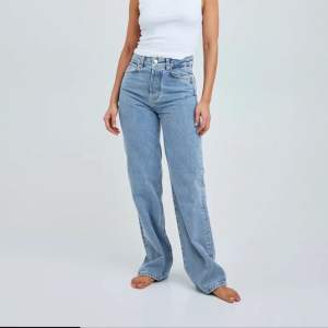 Blå jeans från bikbok som är avklippta nertil då de är väldigt långa, strl 27 och längd 32. 