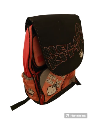 Hello Kitty ryggsäck  - Hello Kitty ryggsäck i använt skick. Vet inte ifall det går att tvätta bort fläcken ni ser på andra bilden. Annars är det inga andra defekter. Väldiht många fack och fickor 👍🏻