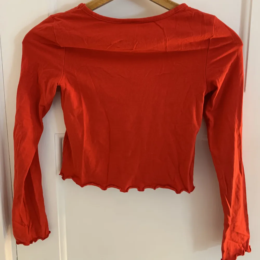 Fin röd långärmade tröja från H&M med detaljer på ärmarna och magen. Storlek xs men passar även en s. Fint skick.. Toppar.