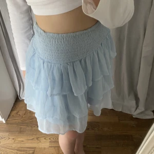 KJOL - Jättefin kort ljusblå kjol. I nyskick då den aldrig är använd. Kjolen är i storlek M men passar lika bra på mig som är i XS/S. Nypris: 400kr