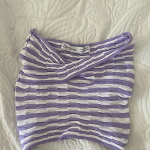 Lila och vit randig topp - Lila och vit randig bandeautopp från Bershka i strl XS. Använd 1 gång. 80kr + frakt