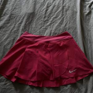 En rosa/cerise tenniskjol från Nike. Strl S. Har innerbyxor. 