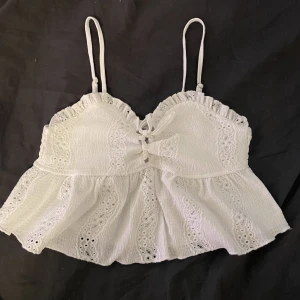 Sommar topp - En vit jätte söt sommar topp som verkligen passar till allt. Sitter jätte fint går att spänna ut och in vid bysten. Aldrig använd för den var för liten. Köparen står för frakten och jag står inte för postens slarv.