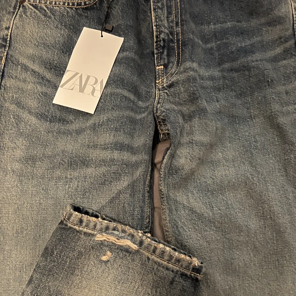 Blåa jeans från Zara med slits nedtill, prislapp kvar aldrig använda. Jeans & Byxor.