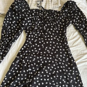Klänning - En svart fin klänning med vita blommor (se bild) super fin och finns inte att köpa samma sort längre!🤍 storlek M men skulle säga att den mer passar S