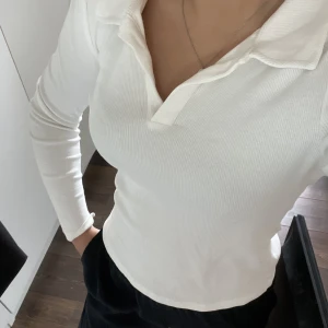långärmad med v-ringning - Fin vit långärmad från Vero Moda. lite räfflat material med en krage upptill. strl M men passar mig som vanligtvis bär S🌸 OBS! sminkfläclar i insidan av kragen som jag inte fått bort därav priset (skriv för fler bilder)