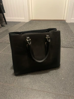 svart väska  - Svart väska från H&M med flera fack inuti! Kommer ej till användning