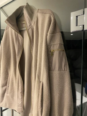 Teddy jacka  - Teddy jacka i beige med guld detaljer 