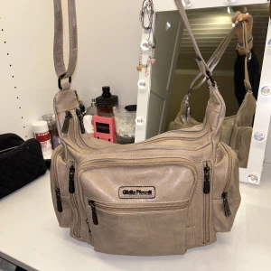 Giulia pieralli väska - Super fin och populär Giulia pieralli väska i en neutral tonad rosa/beig färg i mycket god skick! Flertal fack som öppnas med hjälp av dem stiliga svarta dragkedjorna som ger en sjukt fin touch till väskans utseende. Väskans ordinarie pris är 899kr:)